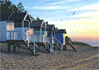 A painting of beach huts at Wells-next-the-Sea at dusk by Margaret Heath.